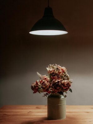 A warm, minimalist floral arrangement under soft lamp light, enhancing a cozy interior atmosphere.